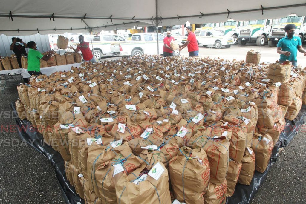 Namalco Construction Services employees prepare hampers to distribute to people in need at the company's headquarters, La Brea Industrial Estate on Saturday.  - Photo by Lincoln Holder