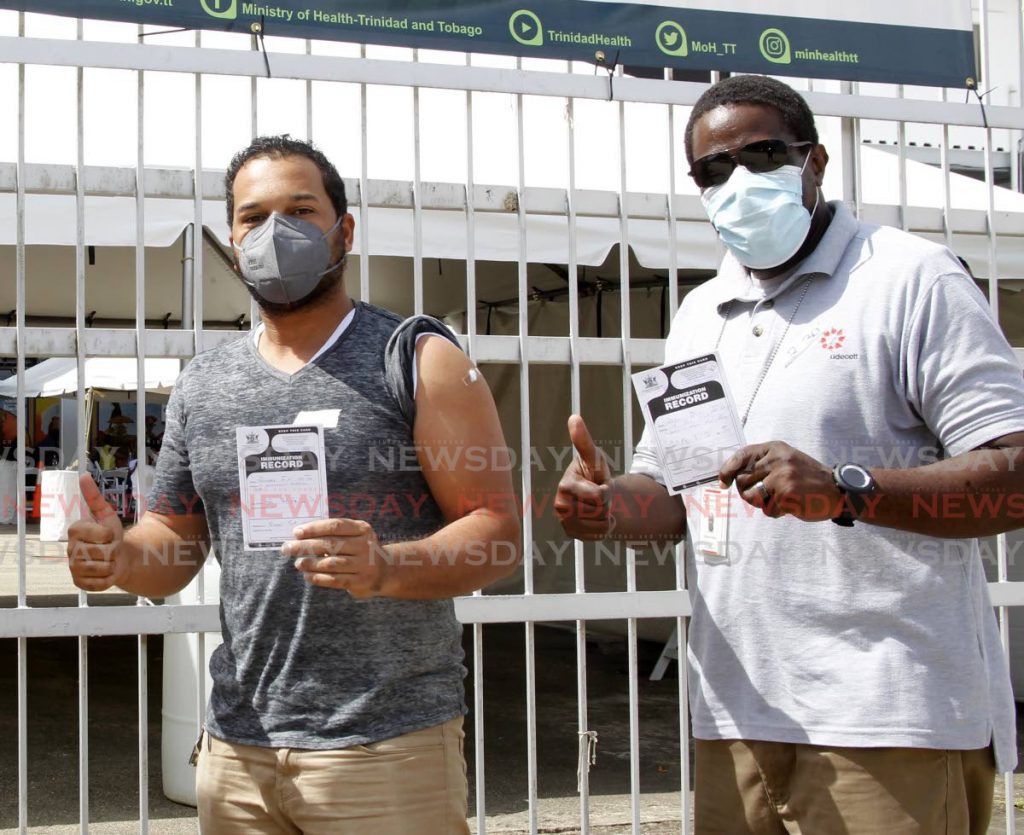 File photo: Construction sector employees Johnson Smith and Atiba De Silva show their vaccination cards after receiving their second dose of the Sinopharm covid19 vaccine during a mass vaccination drive for the construction sector hosted by Udecott and the Ministry of Health at the Paddock, Queen's Park Savannah, Port of Spain on July 3.  Photo by Roger Jacob