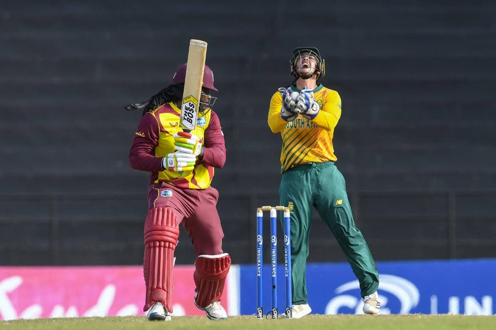 Quinton de Kock (R) of South Africa celebrates taking the catch to dismiss Chris Gayle (L) of West Indies during the 5th and final T20I at Grenada National Cricket Stadium, Saint George's, Grenada, on Saturday. South Africa won the series 3-2. - (AFP PHOTO)