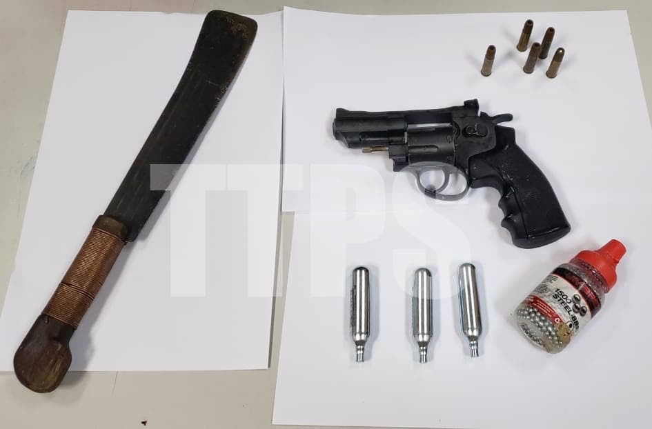 SEIZED: The cutlass, revolver, bullets and pellets seized after a Couva man was arrested when he threatened his ex-wife and also damaged a car. PHOTO COURTESY TTPS - 