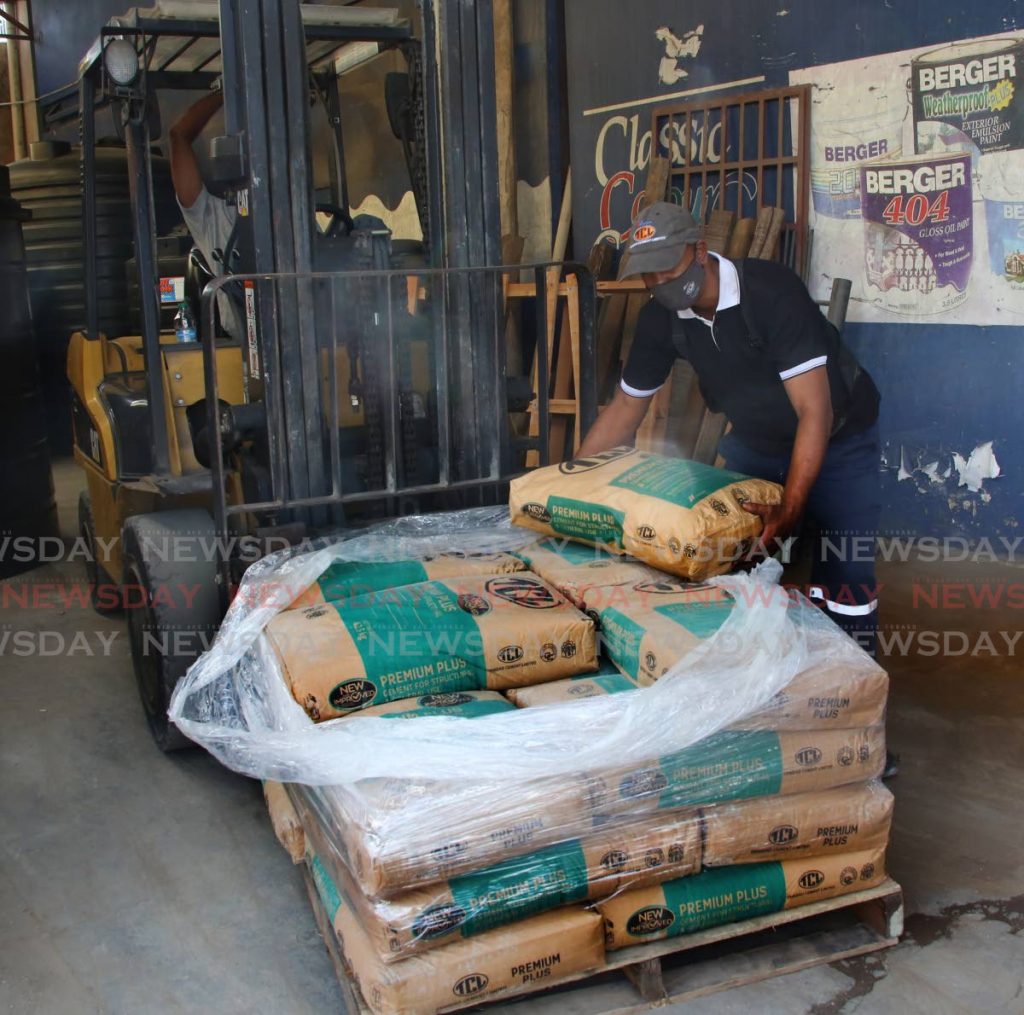 A worker at Aranguez hardware loads bags of TCL cement for a customer on July 5. TCL on Thursday announced $446 million in revenue for the second quarter of 2021. - Photo by Sureash Cholai