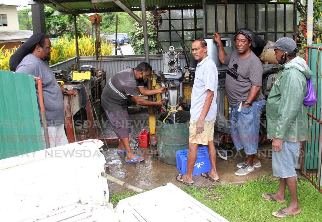 Brandon Gopaul  repairs a 75hp boat engine, at his La Ruffin, Moruga garage on July 6. People from as far as Guayaguayare, Cedros, Woodland and Claxton Bay come to Gopaul's garage to repair their boat engines. - Angelo Marcelle