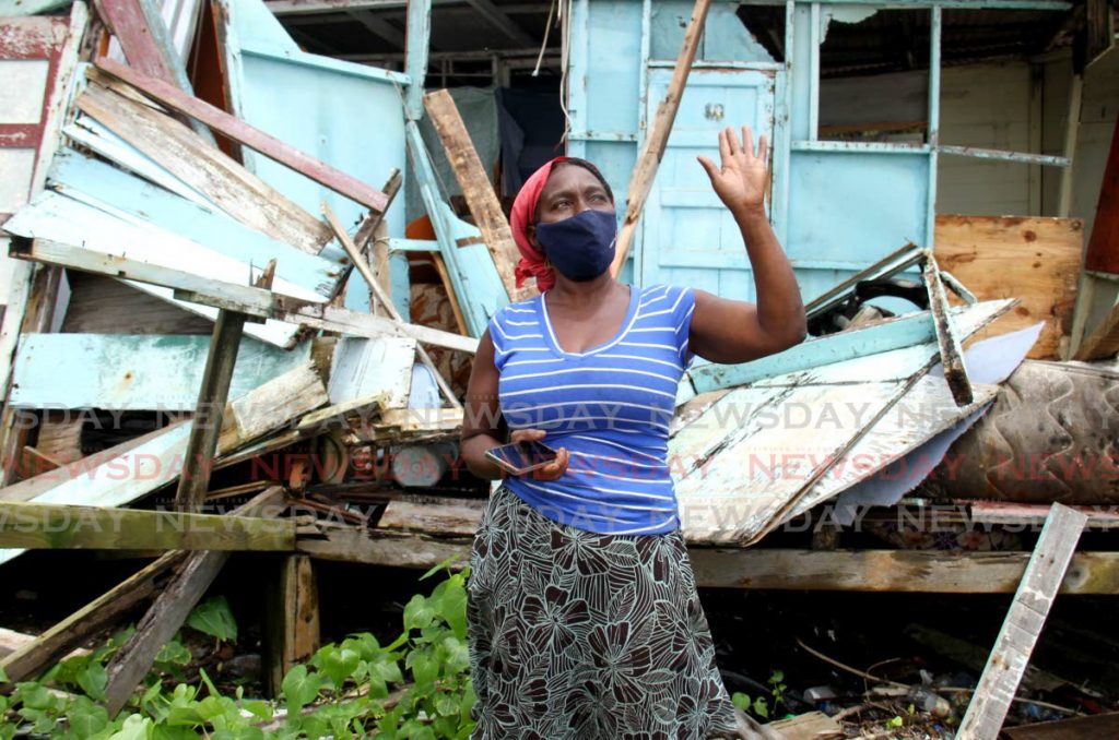 Catherine George lifts her hand in prayer after her house was destroyed by the strong winds and heavy rainfall on Queen Street,
 La Brea - Photo by Ayanna Kinsale