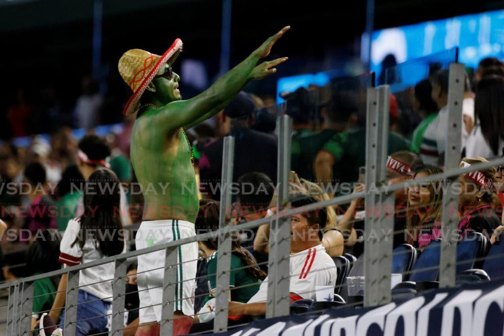A Mexico fan tries to calm down the crowd, which was threatened with the game against TT being suspended on Saturday due to racist chants. AP PHOTO - 