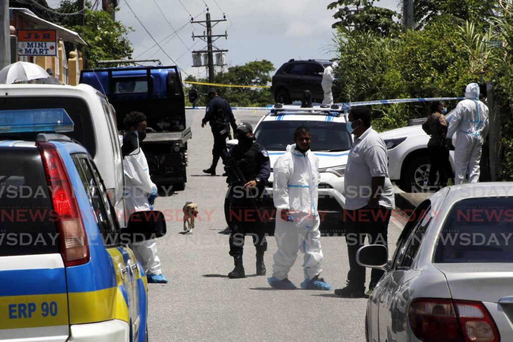 In this file photo, police and crime scene investigators at the scene of a triple murder in Arima, - Photo by Roger Jacob