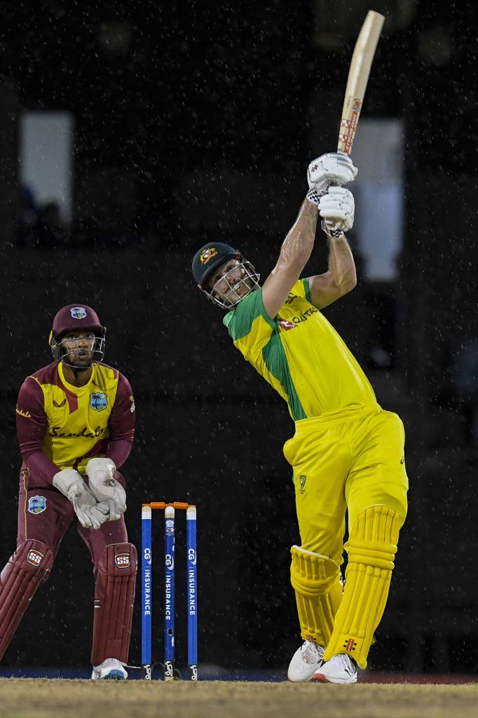 Mitchell Marsh (R) of Australia hits 6 to bring up his half century and Nicholas Pooran (L) of West Indies watch during the 4th T20I between Australia and West Indies at Darren Sammy Cricket Ground, Gros Islet, Saint Lucia, on Wednesday. - (AFP PHOTO)