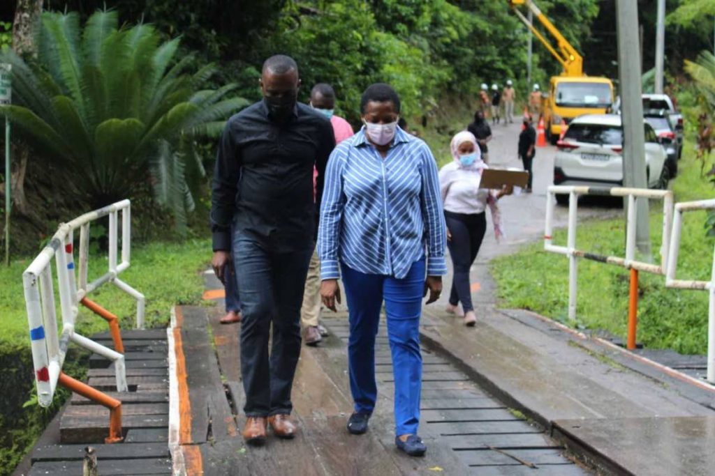 ARIPO STROLL: Public Utilities Minister Marvin Gonzales and Arima MP Pennelope Beckless cross a wooden bridge in the Heights of Aripo on Thursday where they went to witness the installation by TTEC of LED lights in the previously unlit area. PHOTO COURTESY MINISTRY OF PUBLIC UTILTIES - Min Pub Uti