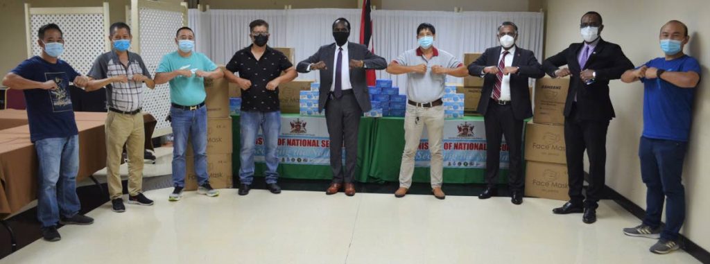 Minister of National Security Fitzgerald Hinds, ministry officials and members of the Chinese business community at the handover of 68,000 face masks for the Ministry of National Security.   - Photo courtesy National Security Ministry 