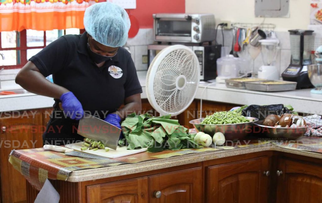 Charlene Reis of Sandra's Gourmet Delight does prep work on Sunday in time for the reopening of the business on Monday. PHOTO BY SUREASH CHOLAI - 