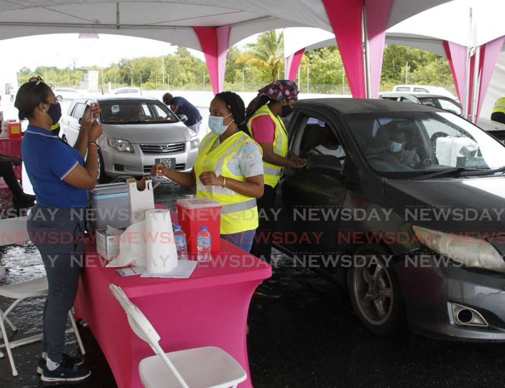 Medical personnel prepare to administer covid19 vaccines to members of the public at the Frankie Boodram Wallerfield International Raceway drive-through site on Friday. - PHOTO BY ROGER JACOB