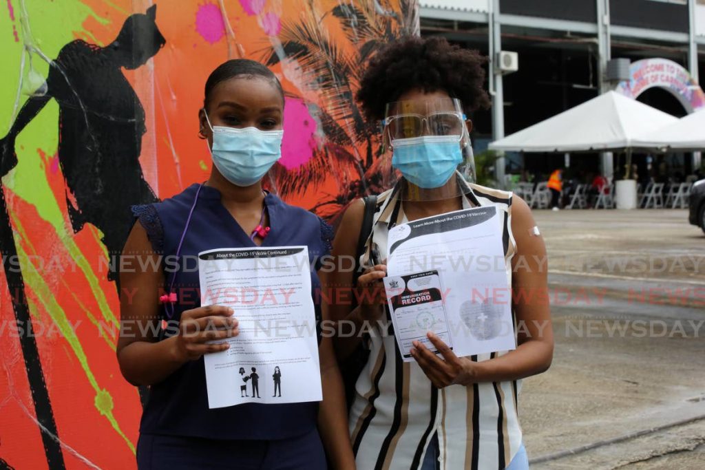 WASA employees Aba Havery Joseph (left) and Tshana Harvey were among the many government employees who showed up at the Queen's Park Savannah to get their covid 19 vaccine on Monday. Photo by Sureash Cholai 