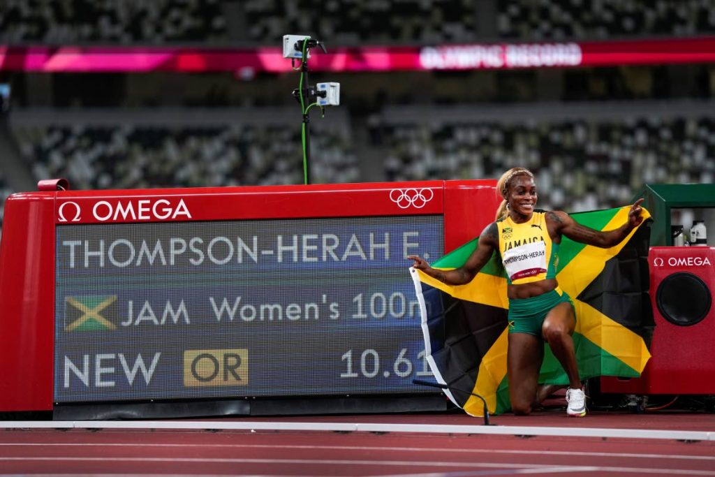 Elaine Thompson-Herah poses with the Jamaica flag after setting a new Games record, after winning the women's 100-metre final at the 2020 Summer Olympics, in Tokyo on Saturday. (AP PHOTO) - 