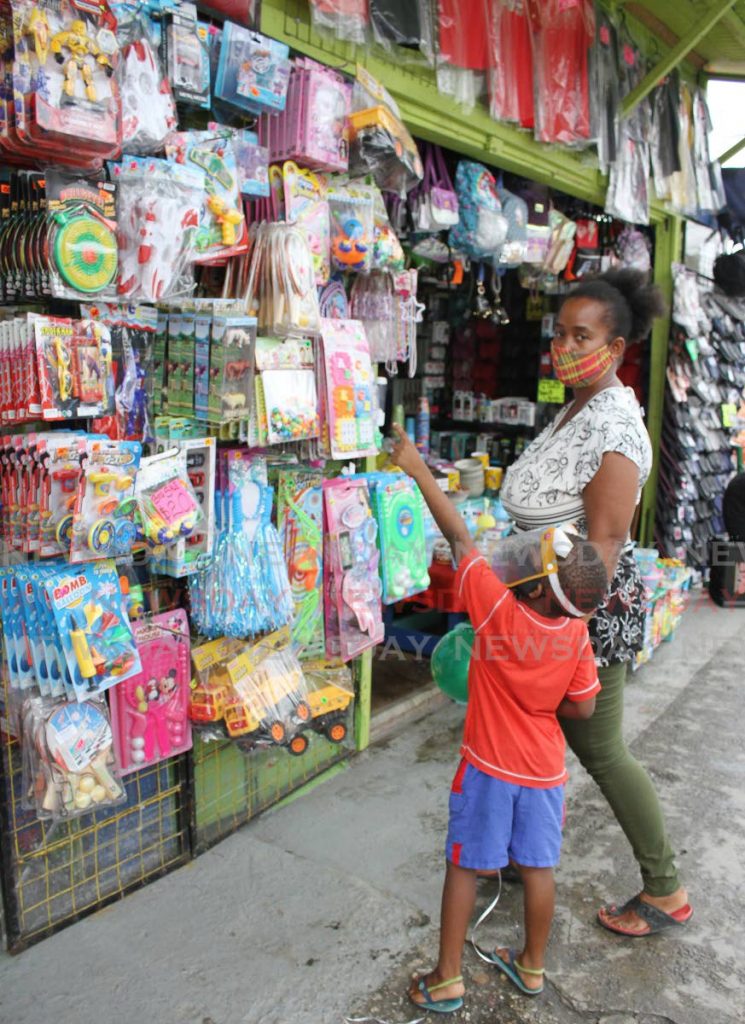 A mother and her son look at toys displayed outside a store. - Photo by Angelo Marcelle