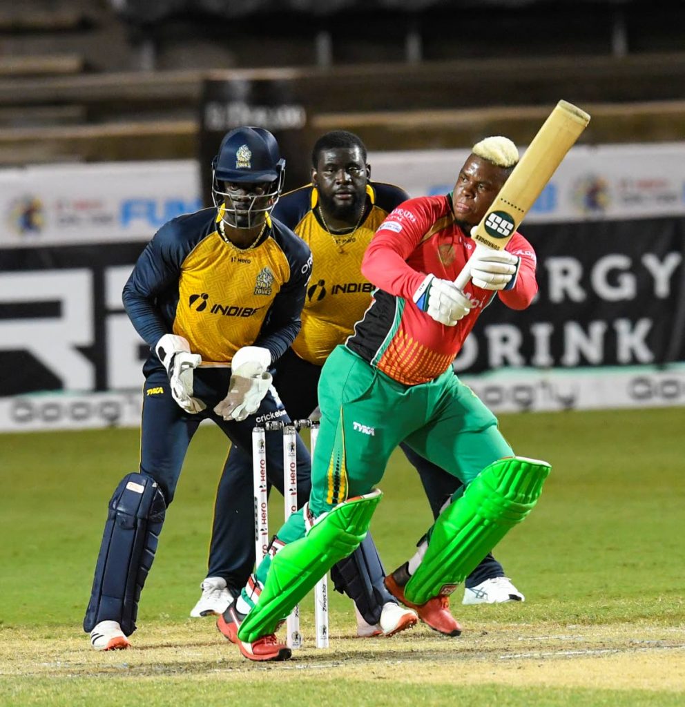 In this September 2, 2020 file photo, Shimron Hetmyer (R) of Guyana Amazon Warriors hits a four as Andre Fletcher (L) and Rahkeem Cornwall (C) of St Lucia Zouks look on during the Hero Caribbean Premier League match at Brian Lara Cricket Academy,Tarouba. - via CPL T20