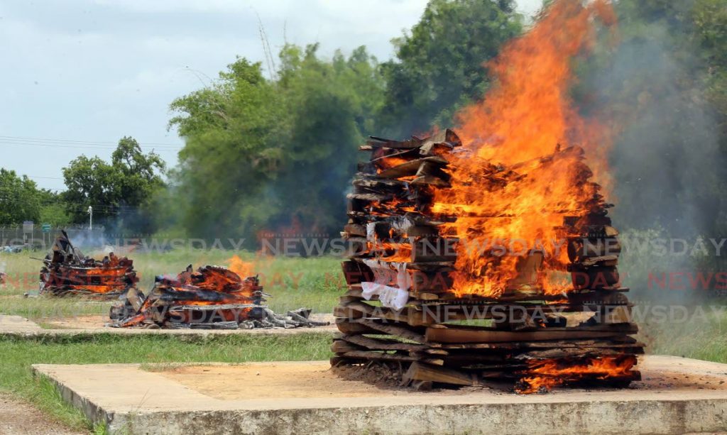 FILE PHOTO: Funeral pyres burn according to Hindu rites at the Caroni Cremation Site on May 26. - SUREASH CHOLAI