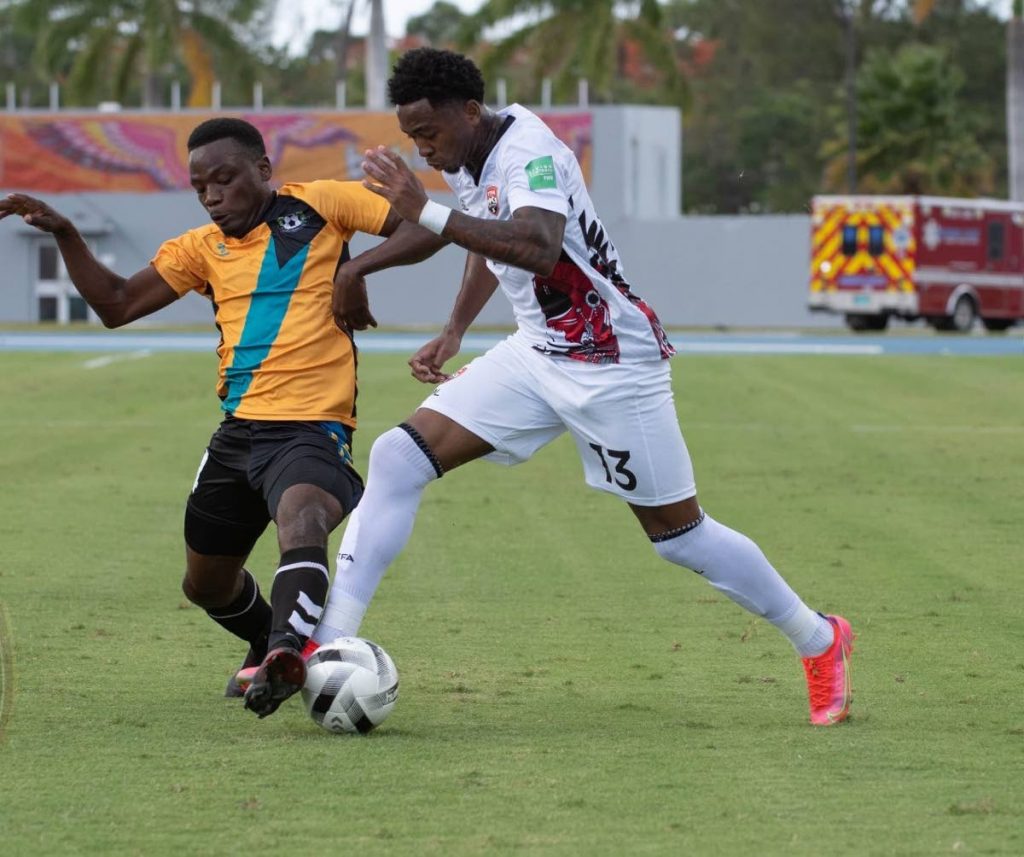 In this June 6, 2021 file photo, Trinidad and Tobago's Keston Julien, right, runs at a Bahamas player in a Concacaf World Cup qualifier at the Thomas Robinson Stadium, Nassau, Bahamas.  - TTFA Media