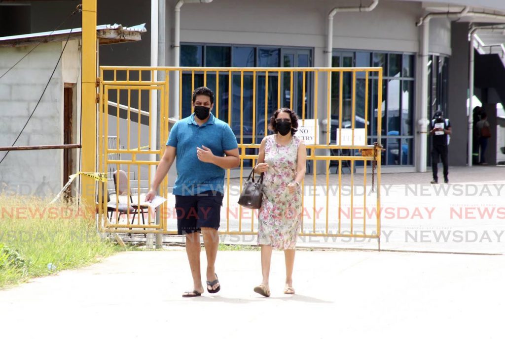 A man and a woman leave the National Racquet Centre after receiving their 1st does of the Oxford Astrazenca vaccine.  - Photo by Roger Jacob