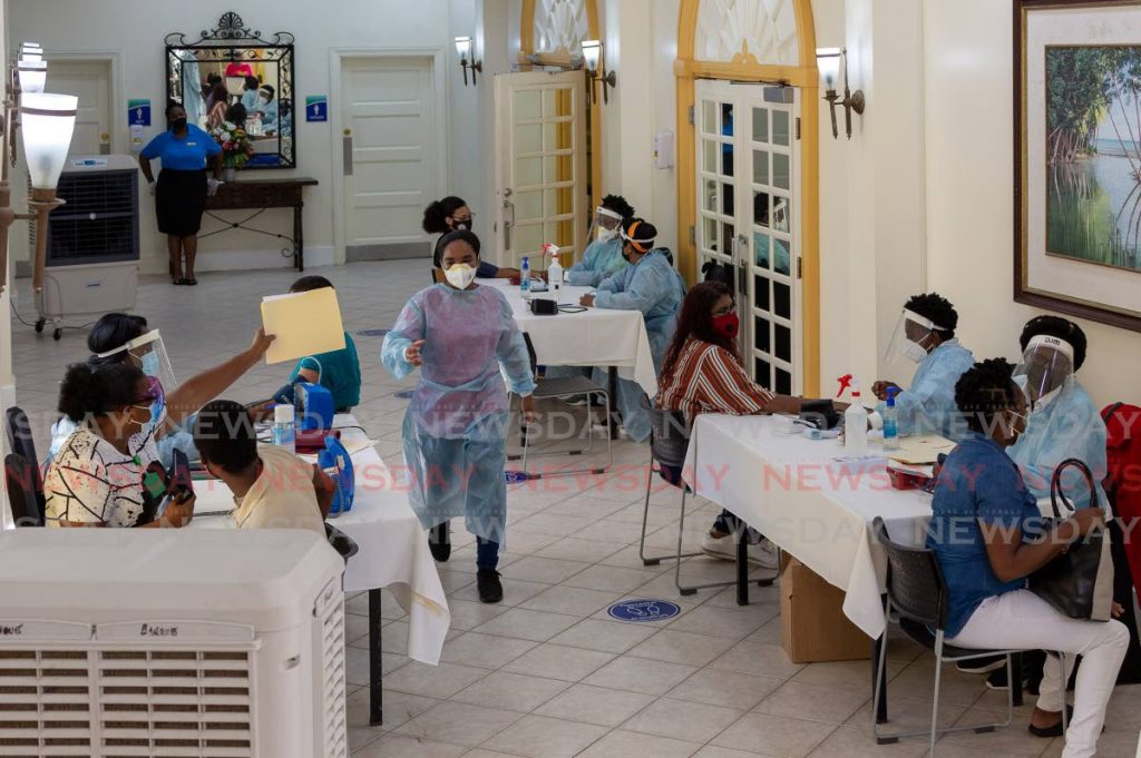In this June 12 file photo, nurses record information from members of the public before giving them covid19 vaccines at Magadalena Grand hotel in Tobago. - File photo/David Reid