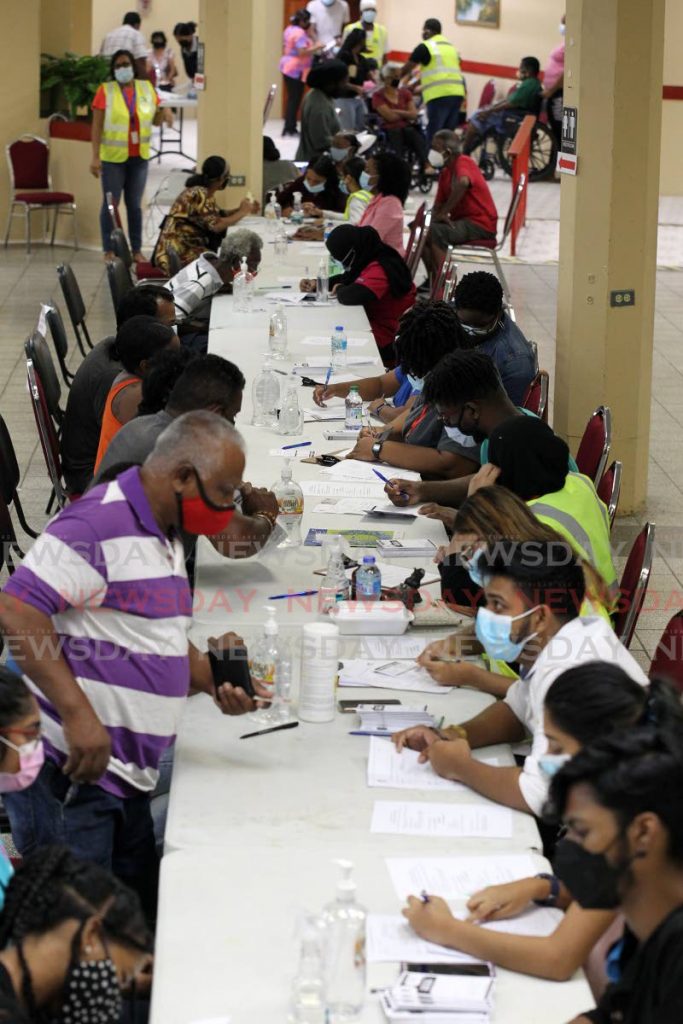 In this photo taken in July, members of the Supermarkets Association register for their covid19 vaccine at the Centre Pointe mall auditorium mass vaccination site, Chaguanas. - File photo/Lincoln Holder