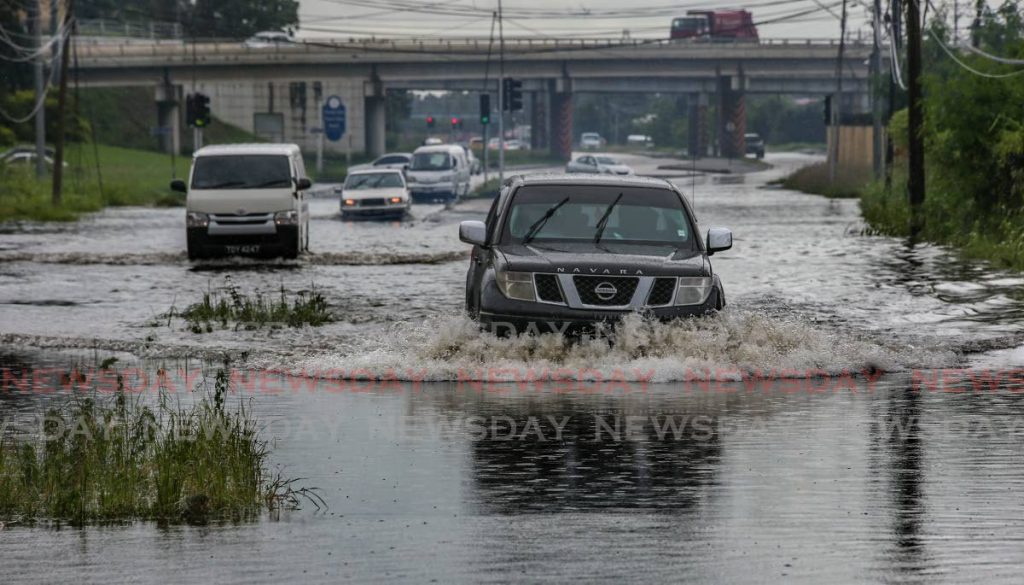 In this July 29 file photo motorists drive through flood along South Quay East, Port of Spain. Photo by Jeff K. Mayers