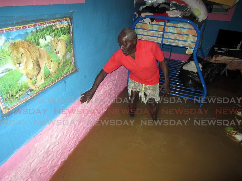 FLOODED OUT: Martin Ottley walks in flood waters which invaded his home last week in Coalmine, Sangre Grande. PHOTO BY ROGER JACOB - 