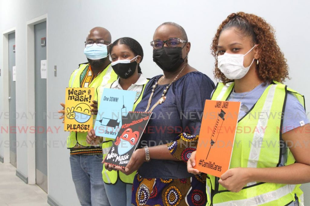 Arouca/Maloney MP Camille Robinson-Regis, second from right, with volunteers holding cards encouraging people to get the covid19 jab during a vaccination drive at the Bon Air Gardens Community Centre, Arouca on Saturday. - Photo by Marvin Hamilton