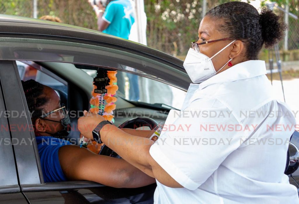 Primary care nurse manager Kathy-Ann Ottley administers a dose of the Sinopharm vaccine to a woman at the Shaw Park drive-through vaccination site. Photo by David Reid
