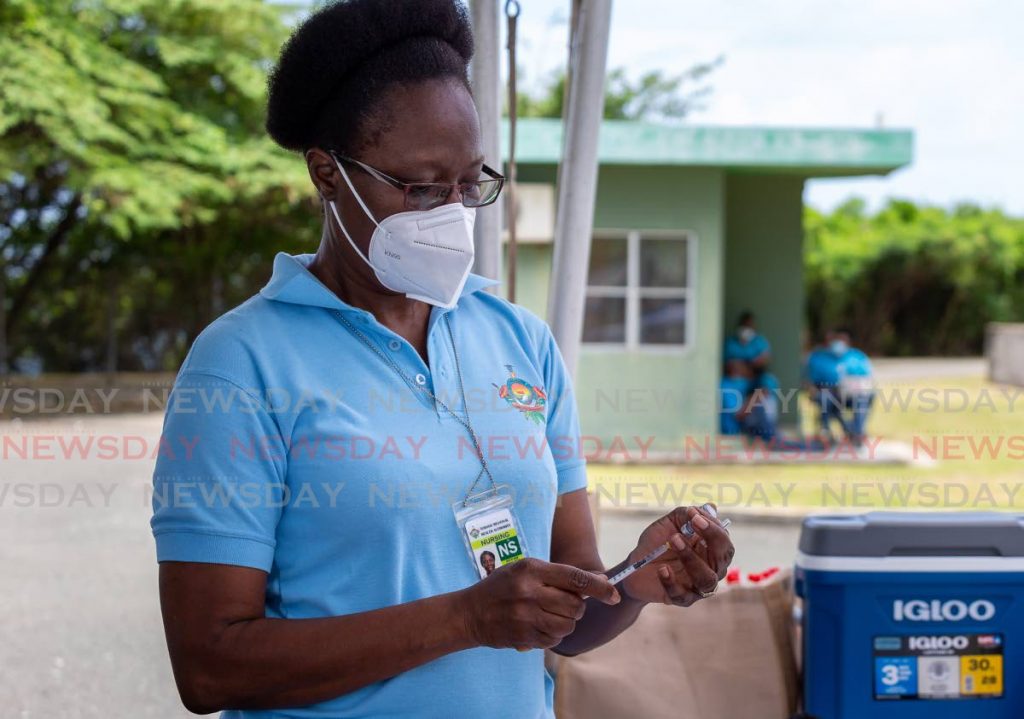District health visitor Denise Nelson prepares a dose of Sinopharm vaccine to administer to a person at Shaw Park, Tobago  on July 31, 2021. Despite the island's vaccination drive, barely one-fifth of the population has recieved two doses of any covid19 vaccine. Photo by David Reid. - 