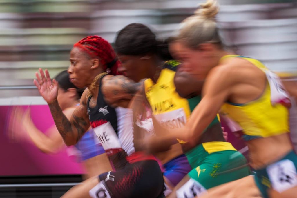 Michelle-Lee Ahye, left, of Trinidad and Tobago, runs in her heat of the women's 100m event at the 2020 Summer Olympics, July 30, in Tokyo. (AP Photo) - 