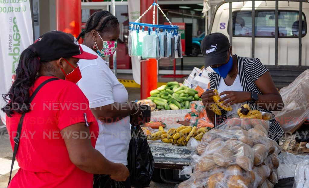 Customers waits to buy fruits and vegetables from a market vendor in Scarborough, Tobago on August 3. Consumers are being spared price increases as headline inflation remained contained at 1.1 per cent, according to the Central Bank. Photo by David Reid - 