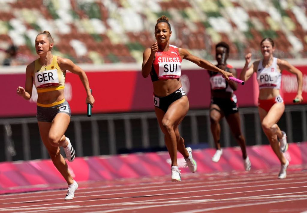 Gina Luckenkemper, of Germany (left), leads Salome Kora, of Switzerland in a semifinal of the women's 4x100-metre relay at the 2020 Summer Olympics, on Thursday, in Tokyo, Japan. TT sprinter Kelly-Ann Baptiste is second from right. (AP PHOTO) - 