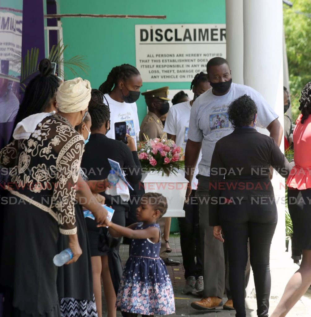 Pallbearers carrying the tiny casket of one of the three children who perished in a house fire at Rookery Nook in Maraval outside the Church of Rock in Morvant after the funeral service. - Photo by Sureash Cholai