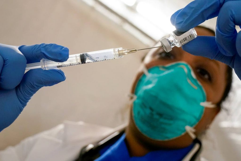 FILE PHOTO: A physician extracts Pfizer-BioNTech covid19 vaccine out of a vial at a vaccination site in New York. - AP PHOTO