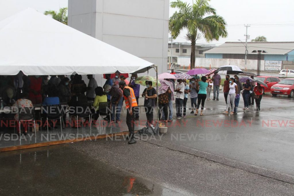 Southerners withstood heavy rain on Monday morning as they waited to get their first jab of the AstraZeneca vaccine at the Southern Academy for the Performing Arts in San Fernando. - Marvin Hamilton