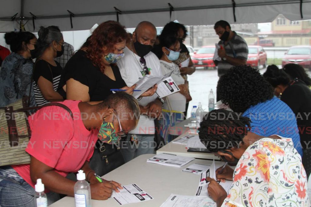 Members of the public register to receive the AstraZeneca vaccine at the Southern Academy for the Performing Arts in San Fernando on August 9. File photo/Marvin Hamilton - 