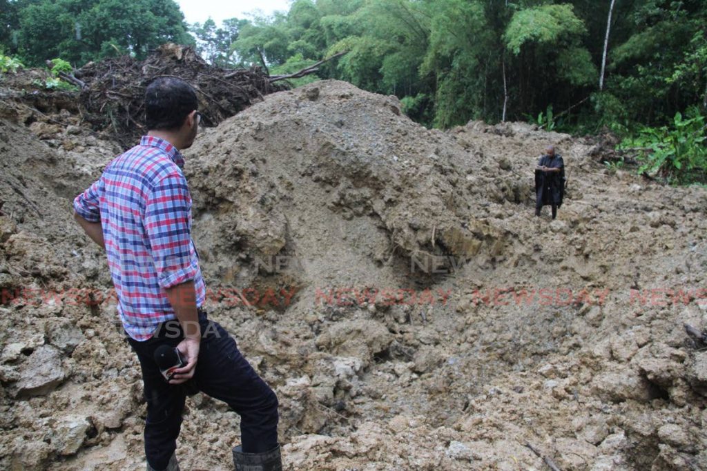 Media personnel look at the hole where the body of Annalisa Gokool was dug out of, at Warden Road, Sangre Chiquito on Monday morning.  - Photo by Angelo Marcelle