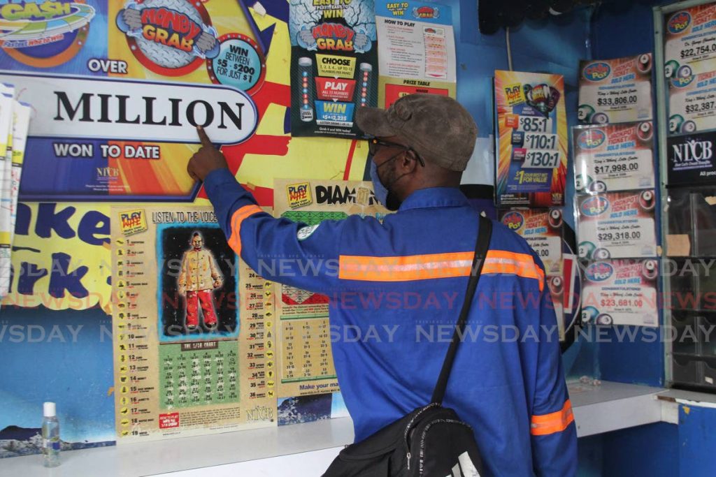 A punter has his finger on the million at a Lotto centre ot King’s Wharf, San Fernando. - Marvin Hamilton