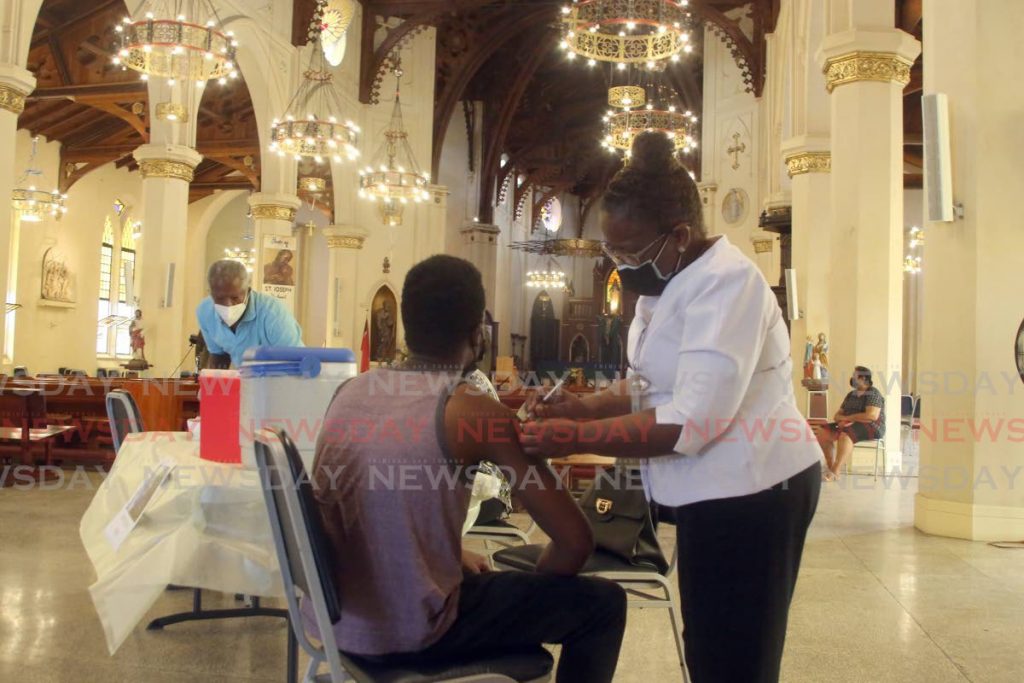 FILE PHOTO: A nurse administers a covid19 vaccine to a man at the Cathedral of the Immaculate Conception, Independence Square, Port of Spain, on Tuesday. - 