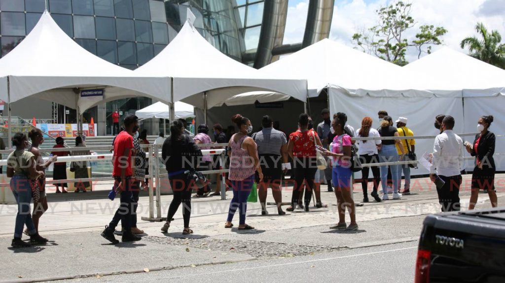Long lines of people awaiting AstraZeneca covid19 vaccine alongside those there for their second dose of the Sinopharm vaccine at the Northern Academy for the Performing Arts (NAPA) in Port of Spain. - Photo by Sureash Cholai