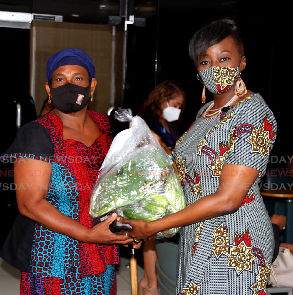 Minister of Social Development and Family Services Donna Cox (right) gives Carol Mungroo a hamper during the hamper distribution ceremony to widows at the Ministry's head office, St Vincent Street, Port of Spain on Tuesday. - Photo by Angelo Marcelle