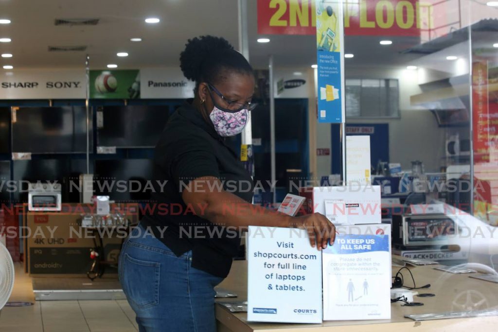 A store clerk at work getting Courts Frederick Street branch in Port of Spain ready for reopening on Monday.  - PHOTO BY SUREASH CHOLAI
