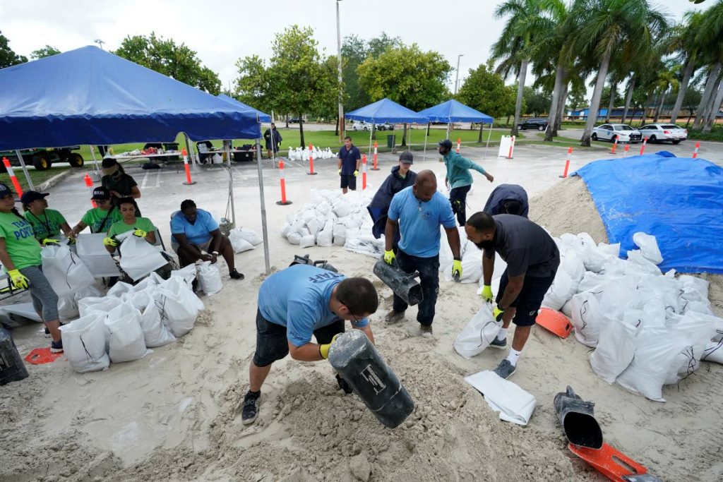 City workers fill sandbags at a drive-thru sandbag distribution event for residents ahead of the arrival of rains associated with tropical depression Fred, on August 13, at Grapeland Park in Miami. Forecasters said tropical depression Fred was expected to regain tropical storm status Friday. AP Photo - 