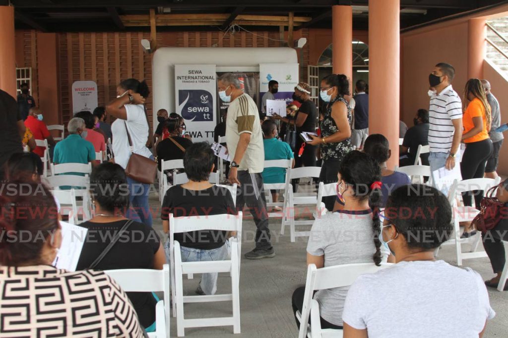 Members of the public wait to get covid19 vaccines at the Divali Nagar vaccination site in Chaguanas on Saturday. - Photo by Marvin Hamilton