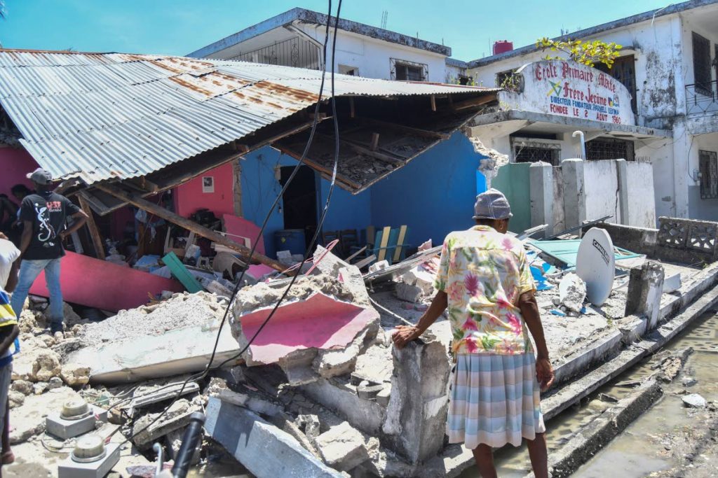 A woman stands in front of a destroyed home in the aftermath of an earthquake in Les Cayes, Haiti on Saturday. AP PHOTO - 