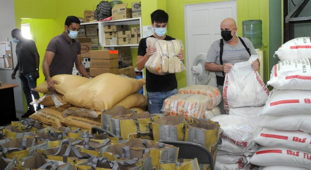 Volunteers at Living Water Community help pack up the grocery items donated by BPTT as part of ts #InThisTogether initiative. - 