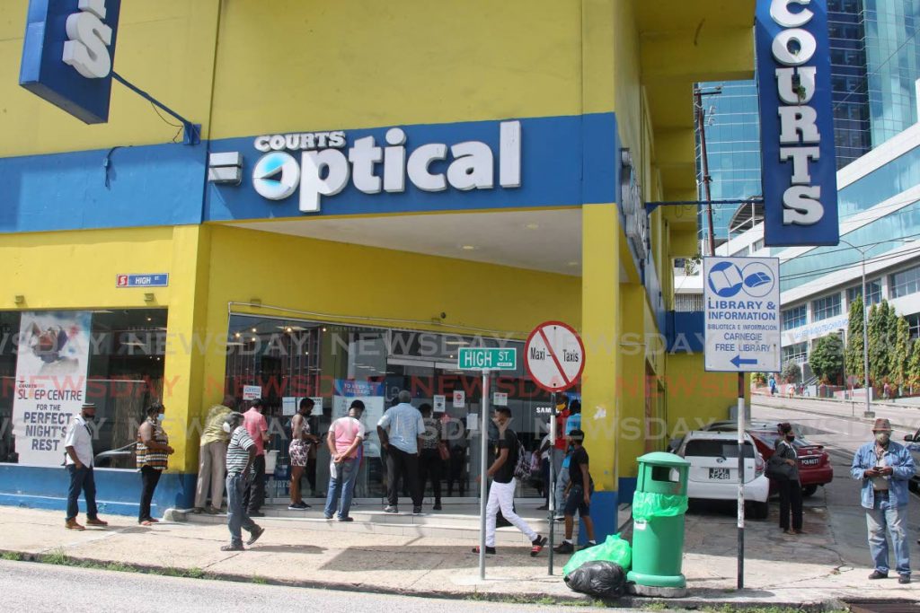 People lined up outside Courts on High Street, San Fernando as the retail sector re-opened for business after being closed for three months. Photo by Lincoln Holder