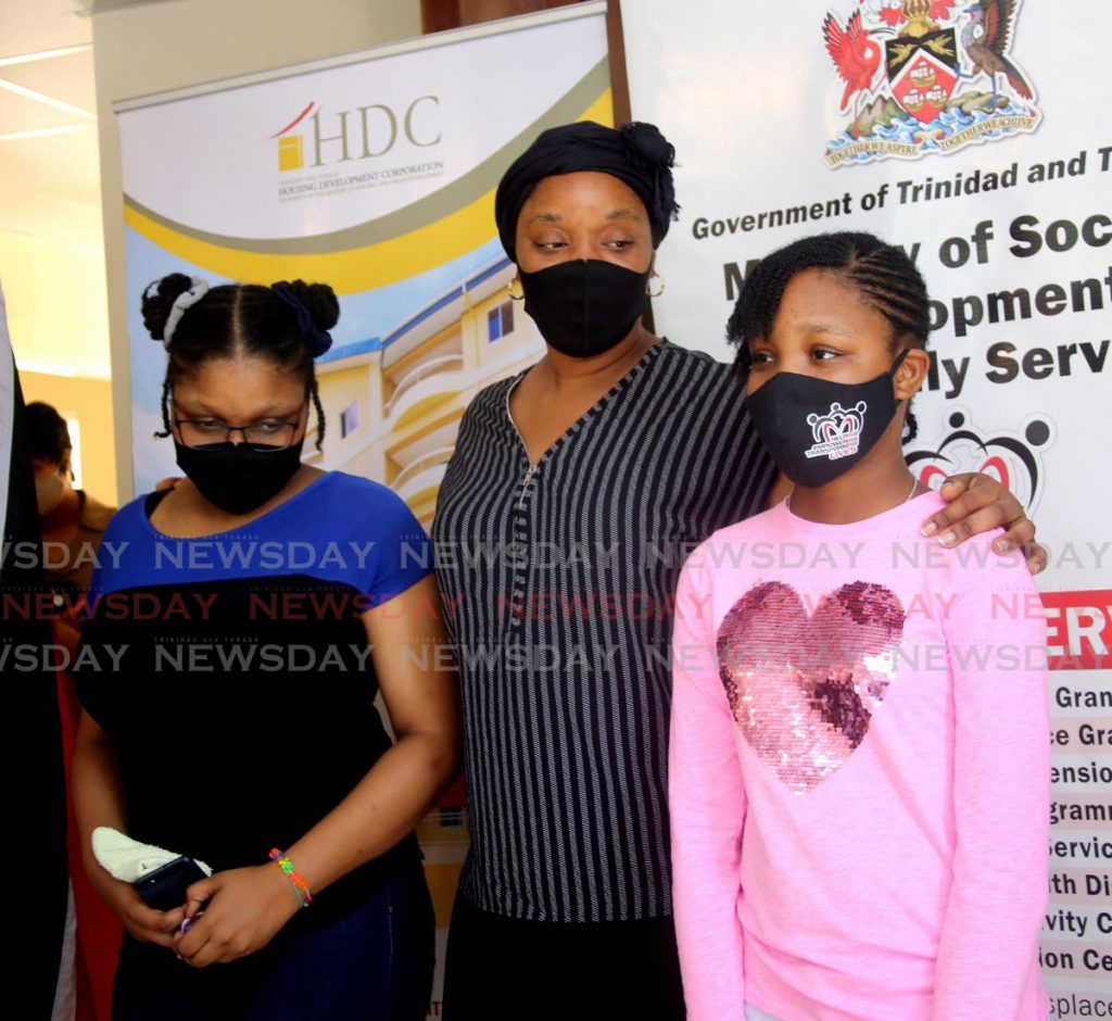 Mother Jenille Rodriguez and her two surviving children Jeniceia, left, and Zaria Burke recieved a HDC home at Vieux Fort in St James on Monday. The family lost three of the siblings and their Maraval home to fire last month.

Photo by Sureash Cholai 