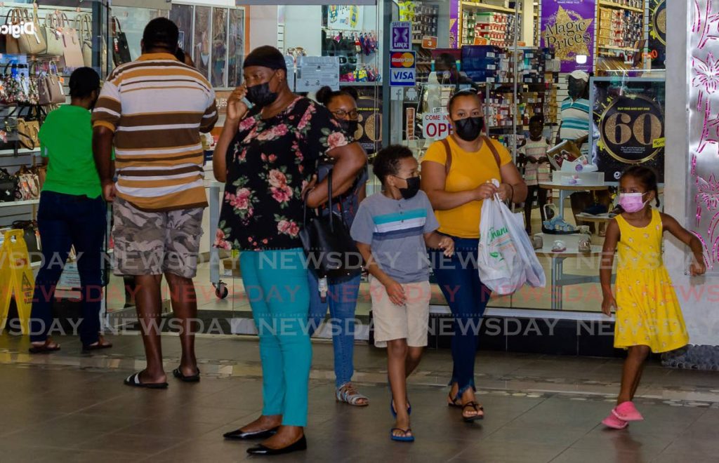 Shoppers move about at Gulf City Mall, Lowlands on Monday. In comparison, store owners in Scarborough said there were few sales despite people visiting the establishments.  Photo by David Reid