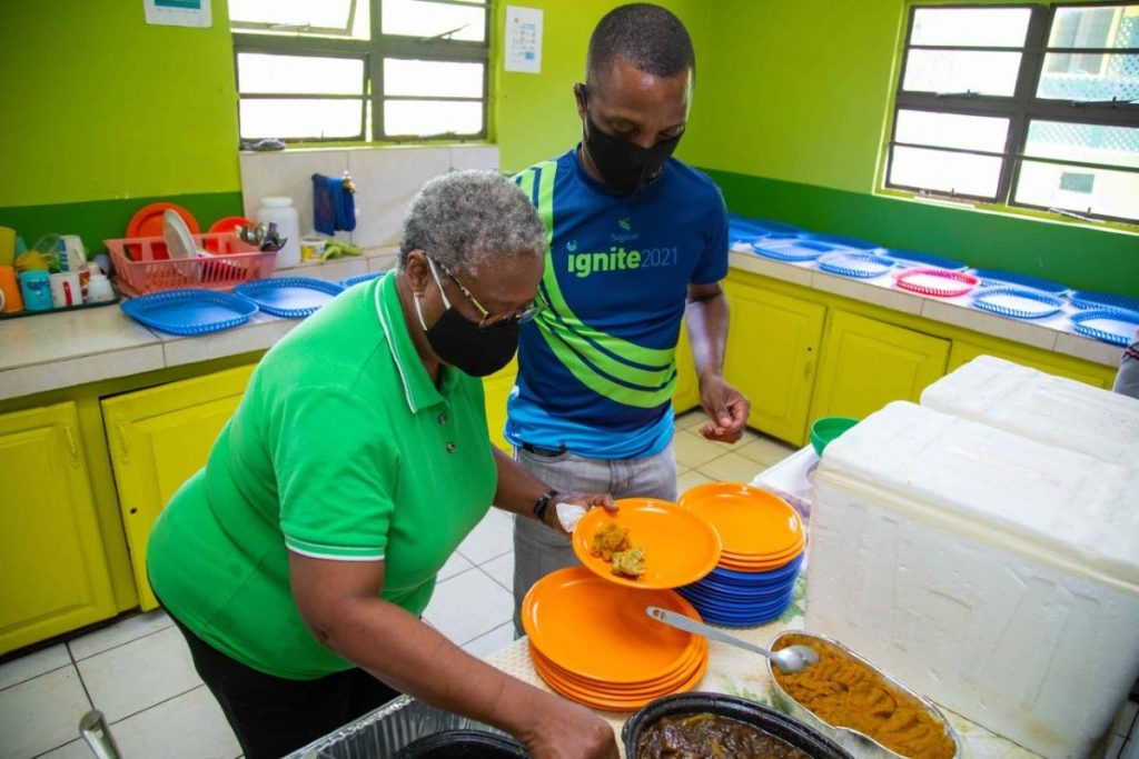 Sagicor advisor Kido Phillander, attached to the Patti Hudson-Bowen Unit, assists with plating food for Sunday lunch. - 