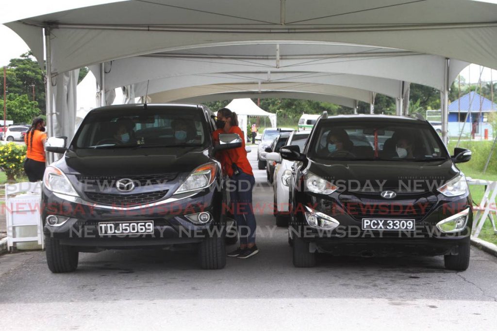 Parents took their kids to the Ato Boldon Vacination site in Couva to get the first jab of the  Pfizer vaccine on Thursday. - Photo by Marvin Hamilton